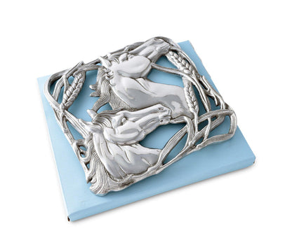 Cast aluminum trivet featuring two sculpted horse heads facing opposite directions, surrounded by an ornate border of intertwined wheat stalks