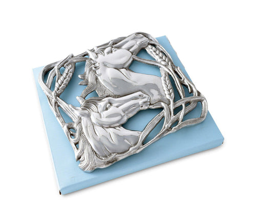 Cast aluminum trivet featuring two sculpted horse heads facing opposite directions, surrounded by an ornate border of intertwined wheat stalks