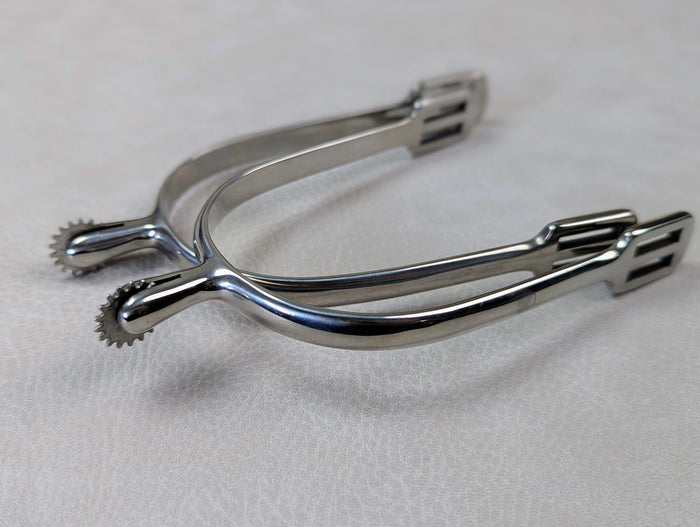 silver english spurs with small rowel on a textured grey table