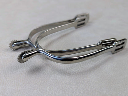 silver english spurs with small rowel on a textured grey table