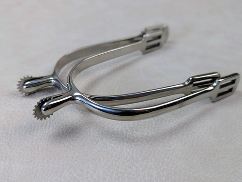 silver english spurs with small rowel on a textured grey table