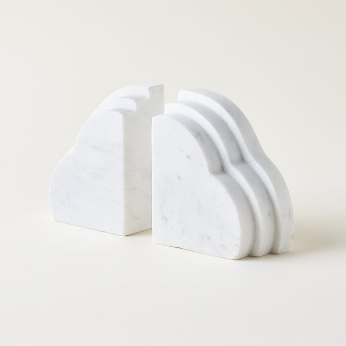Set of 2 cloud-shaped white marble bookends on a light background. Home decor styled for a kid's room or living room bookshelf.