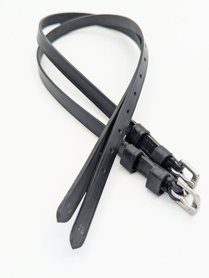 Black leather spur straps with square stainless steel buckles, shown laid out to display stitching, adjustment holes, and double keepers.