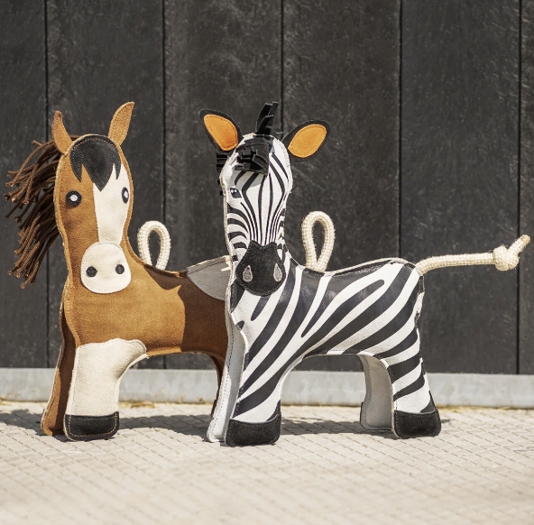 one zebra and one paint horse toy on cobblestone with a black background