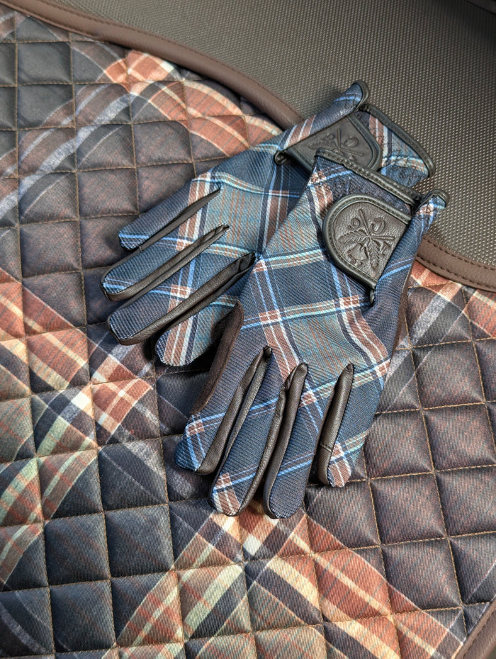 pair of tobacco brown plaid riding gloves on a matching sixteen cypress plaid saddle pad.